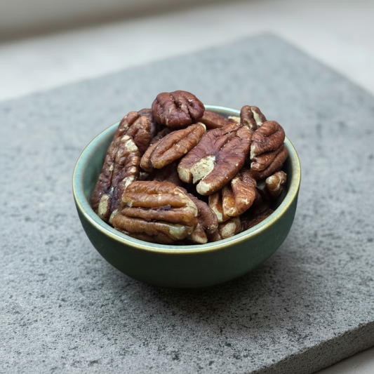 Pecans in a ceramic bowl on a stone slab