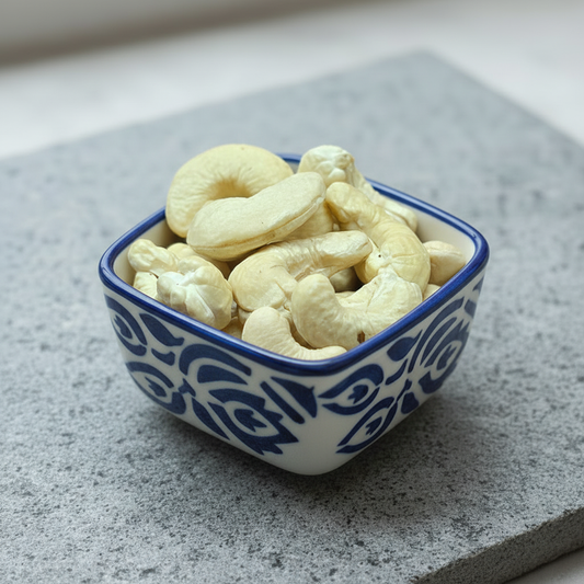 Cashew nuts in a ceramic bowl on a stone slab
