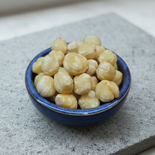 Hazelnuts in a ceramic bowl on a stone slab